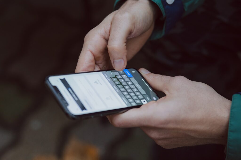 Mężczyzna pisze wiadomość na telefonie iPhone X - smartfony z dobrą baterią